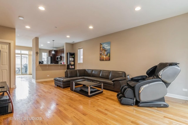 living area with baseboards, recessed lighting, and light wood-style floors