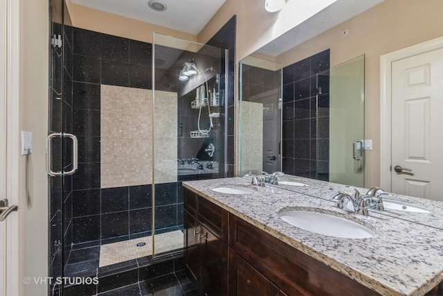 full bathroom with double vanity, a stall shower, and a sink