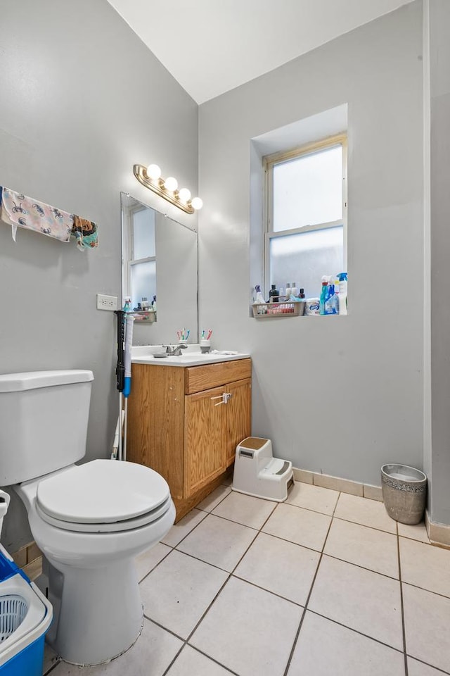 bathroom with toilet, vanity, and tile patterned flooring