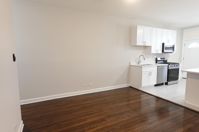 kitchen with sink, light wood-type flooring, white cabinetry, and stainless steel appliances