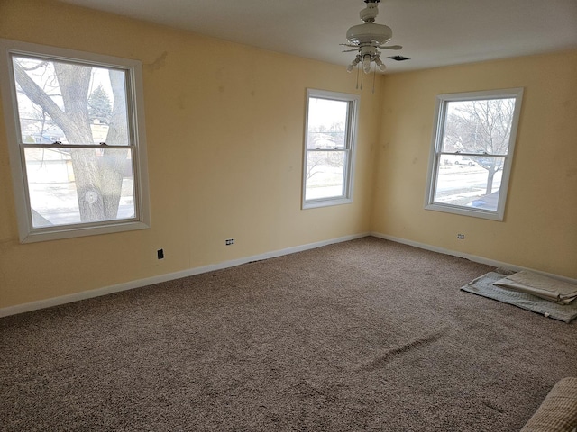 carpeted spare room featuring ceiling fan