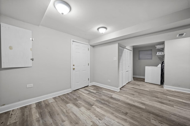 basement featuring washer / clothes dryer and light hardwood / wood-style flooring