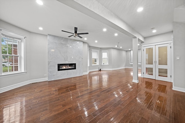 unfurnished living room with plenty of natural light, wood-type flooring, and a premium fireplace