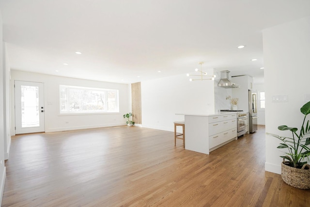 unfurnished living room featuring light hardwood / wood-style flooring and an inviting chandelier