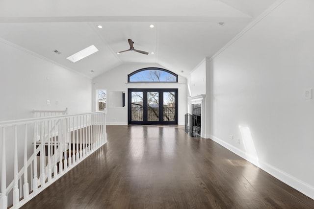 unfurnished living room with ceiling fan, a skylight, high vaulted ceiling, and dark hardwood / wood-style flooring