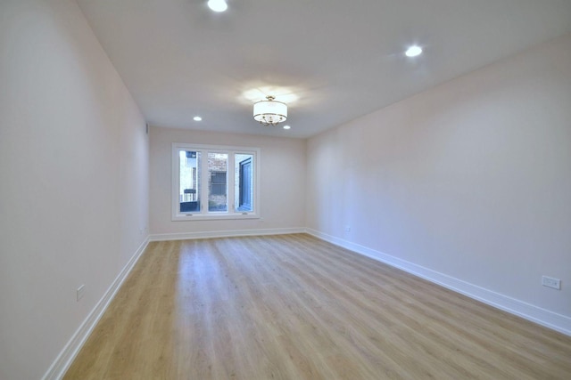 spare room featuring recessed lighting, light wood-type flooring, and baseboards