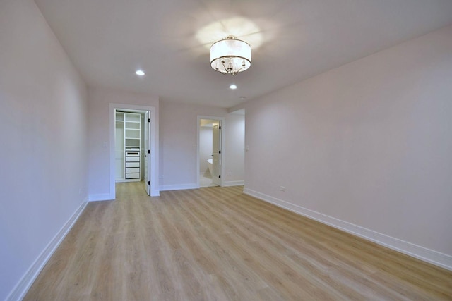 empty room featuring recessed lighting, light wood-type flooring, and baseboards