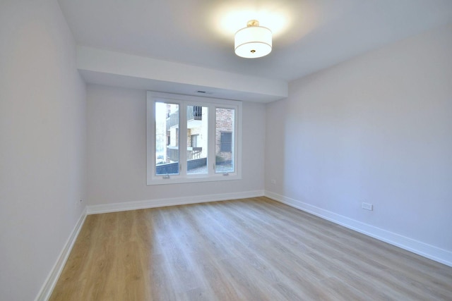 empty room with light wood-style floors and baseboards