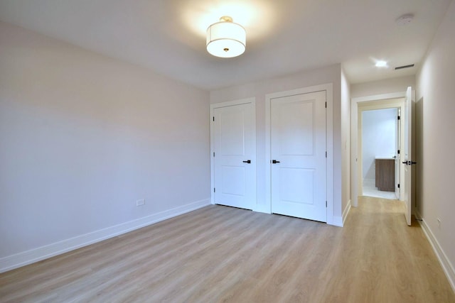 unfurnished bedroom with baseboards, visible vents, and light wood-style flooring