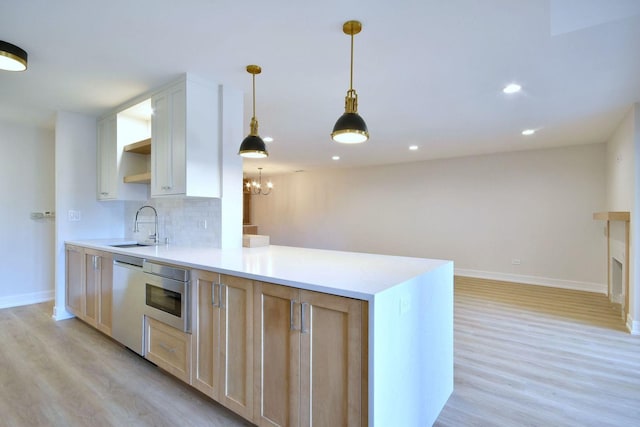 kitchen featuring dishwasher, tasteful backsplash, a sink, and light wood-style floors