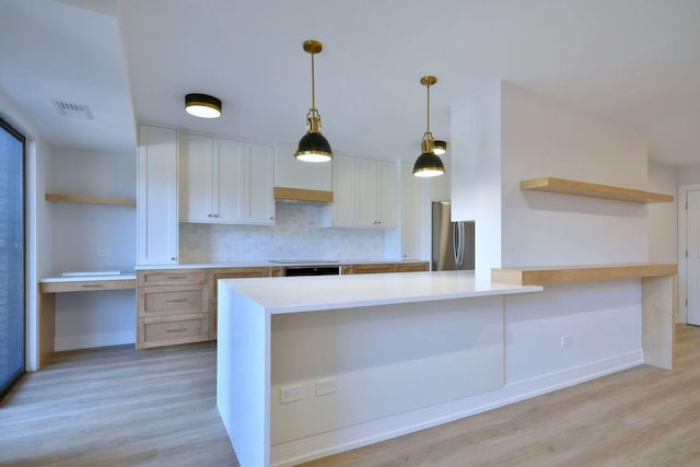 kitchen with decorative backsplash, light wood-style flooring, decorative light fixtures, freestanding refrigerator, and open shelves