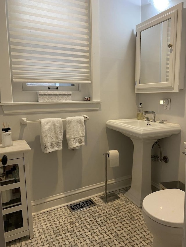 bathroom with wine cooler, toilet, baseboards, and visible vents