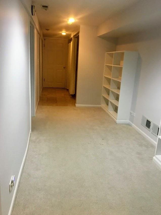 empty room with visible vents, light colored carpet, and baseboards