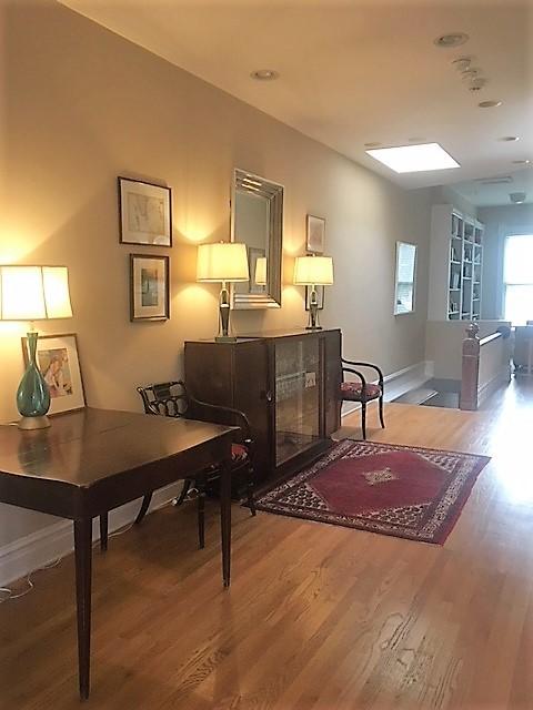 sitting room with baseboards and wood finished floors