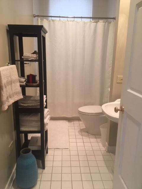 full bathroom with tile patterned floors, toilet, and a shower with shower curtain