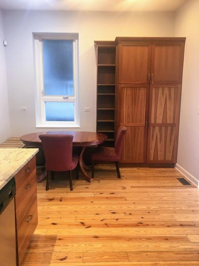 dining space featuring visible vents, baseboards, and light wood finished floors