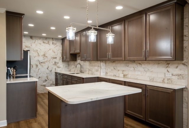 kitchen featuring dark brown cabinets, dark wood-type flooring, a sink, and pendant lighting