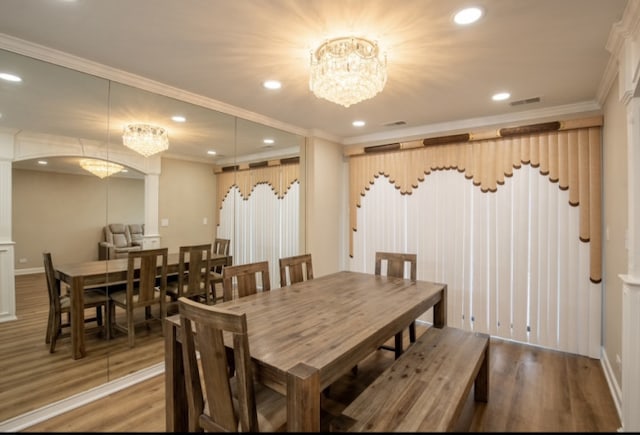 dining space featuring crown molding, recessed lighting, a notable chandelier, and wood finished floors