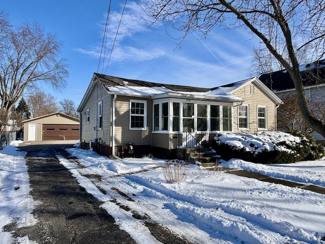 view of front of home featuring a garage and an outbuilding