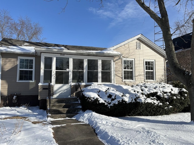 snow covered back of property with entry steps