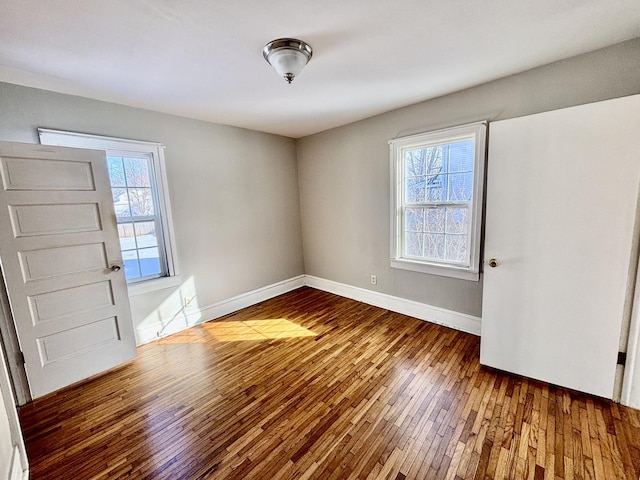 interior space featuring dark wood-type flooring and baseboards