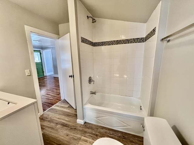 full bath with shower / bath combination, vanity, toilet, and wood finished floors