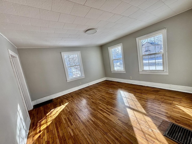 unfurnished room featuring baseboards and wood finished floors