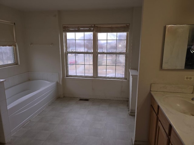 bathroom with a tub and vanity