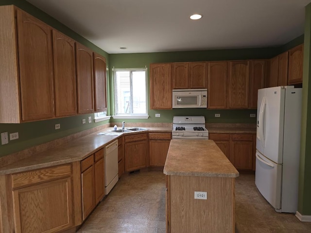 kitchen with sink, white appliances, and a center island