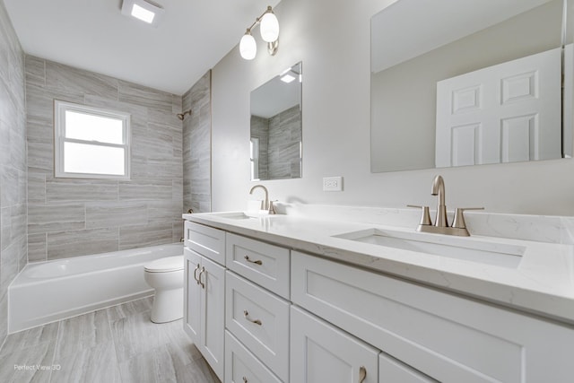 full bathroom with tiled shower / bath combo, vanity, and toilet