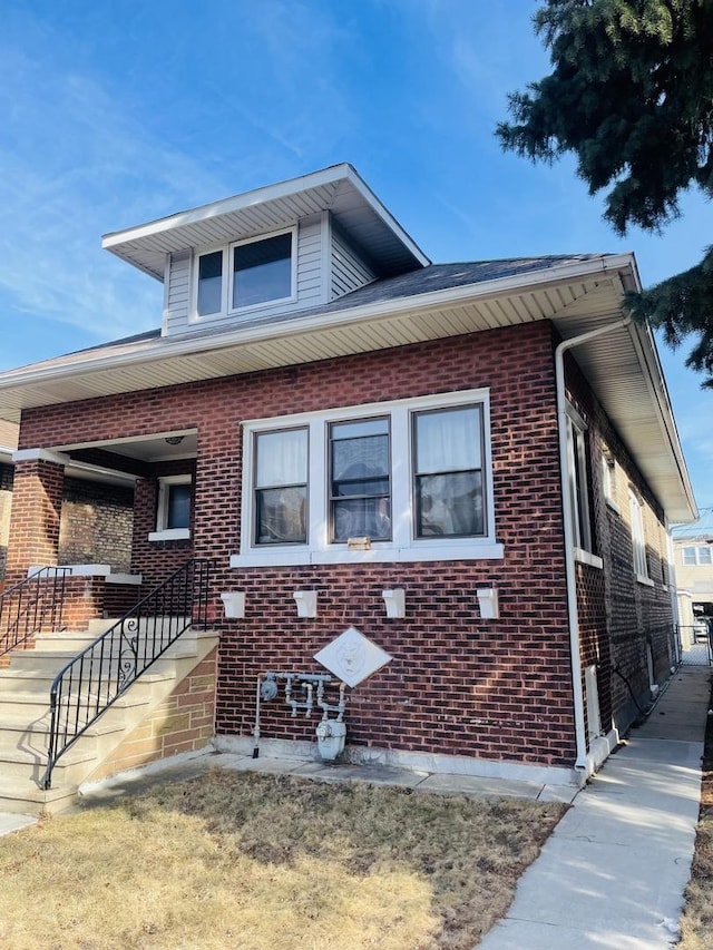 view of front of home with brick siding and stairway