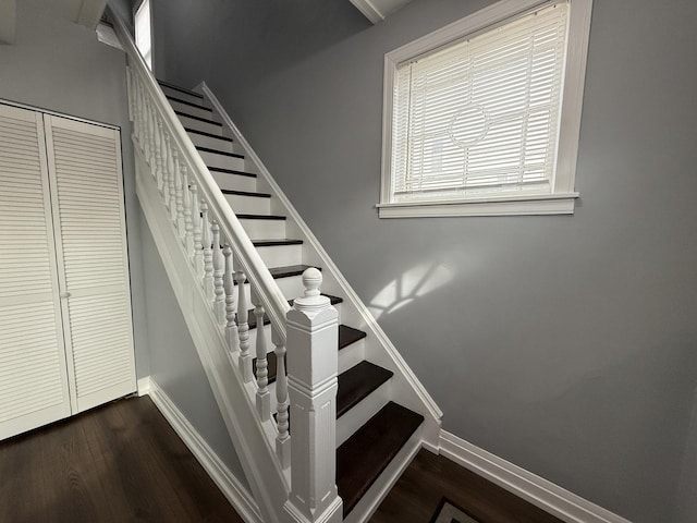 stairs featuring wood finished floors and baseboards