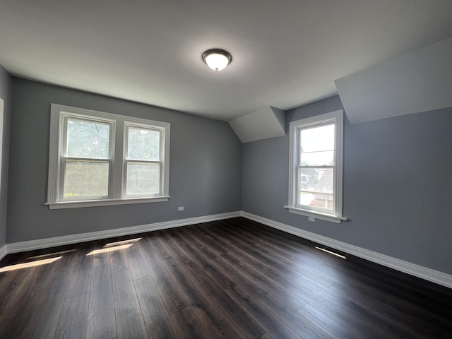 bonus room featuring vaulted ceiling, visible vents, dark wood finished floors, and baseboards