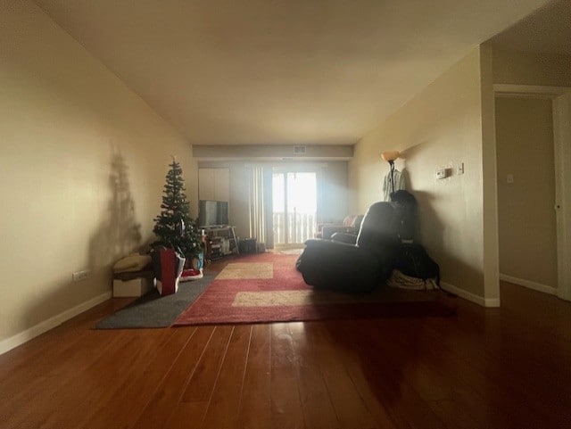 unfurnished living room with dark wood-style floors and baseboards