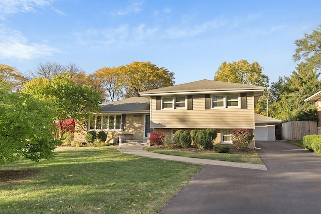 split level home with a front lawn and fence