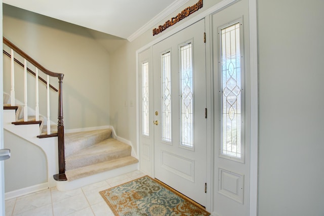 foyer entrance with ornamental molding, stairway, light tile patterned flooring, and a wealth of natural light