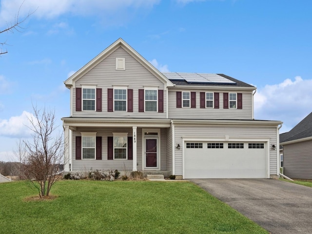 view of front of house featuring a garage, covered porch, driveway, roof mounted solar panels, and a front yard