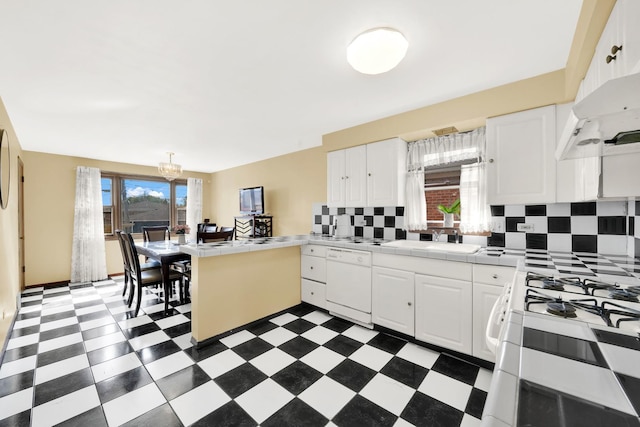 kitchen with white cabinets, tile counters, white appliances, kitchen peninsula, and sink