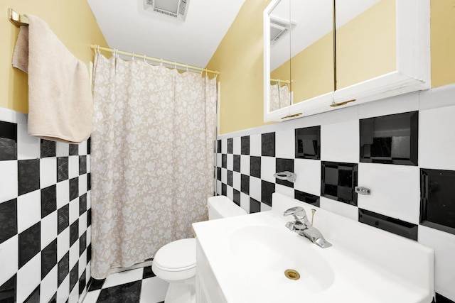 bathroom with toilet, tile walls, and vanity