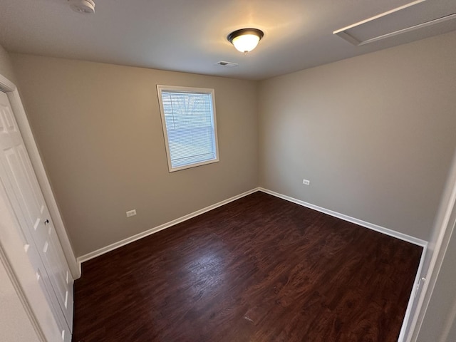 unfurnished bedroom featuring dark wood-type flooring, visible vents, and baseboards