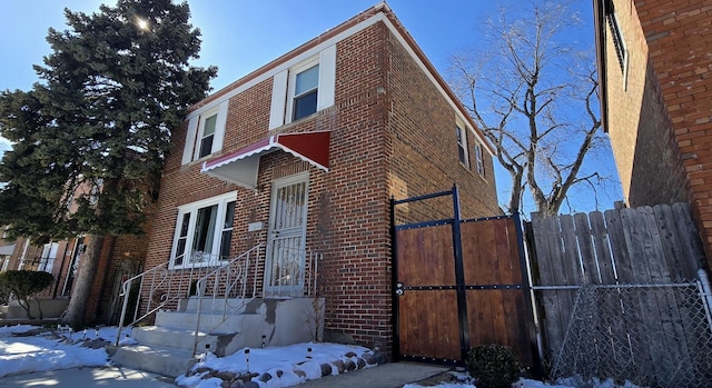 view of front of house with brick siding and fence