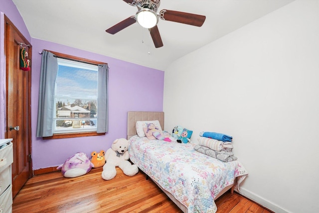 bedroom with light hardwood / wood-style floors, vaulted ceiling, and ceiling fan