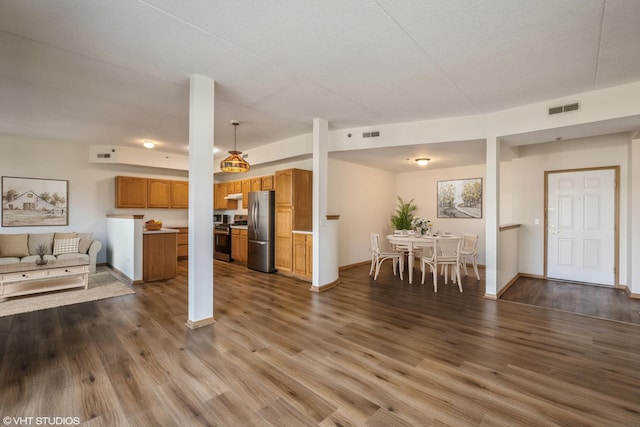 living area with dark wood-style flooring, visible vents, and baseboards