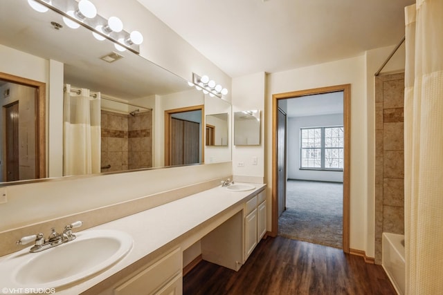 full bath featuring double vanity, visible vents, a sink, and wood finished floors