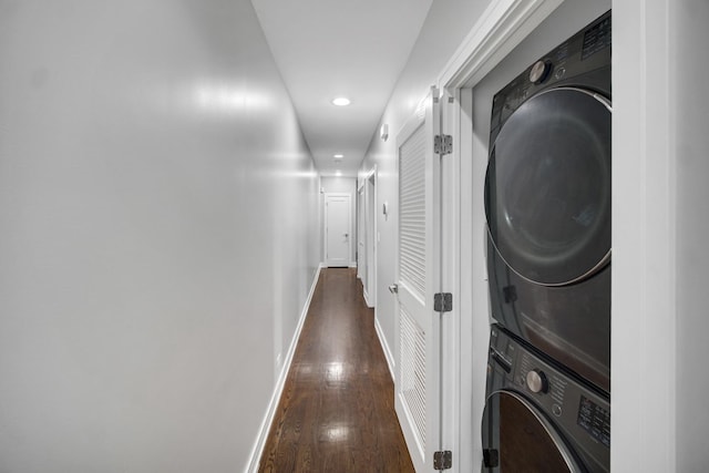 laundry area with baseboards, laundry area, recessed lighting, dark wood-type flooring, and stacked washer and dryer