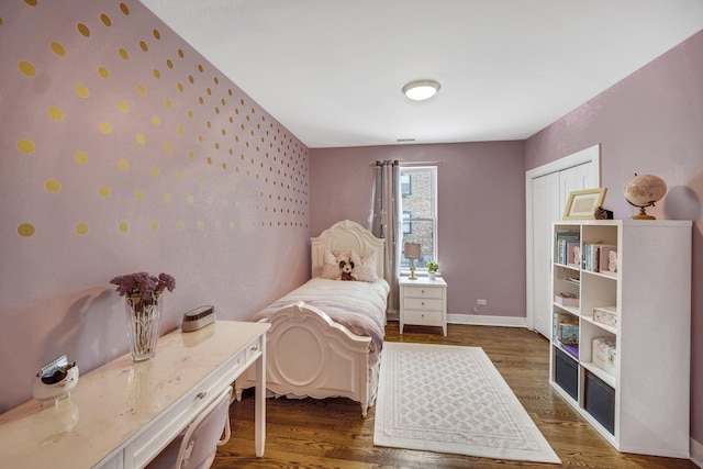 bedroom with a closet, baseboards, and wood finished floors