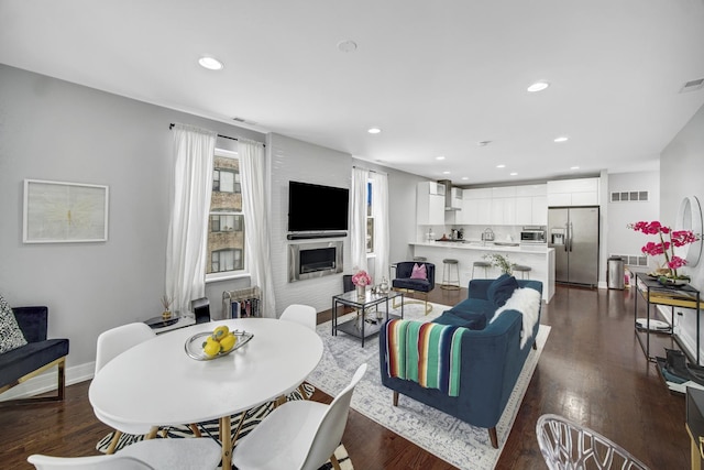 living area featuring visible vents, recessed lighting, a fireplace, and dark wood-style flooring