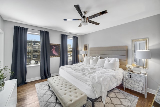 bedroom with wood finished floors, baseboards, and ceiling fan