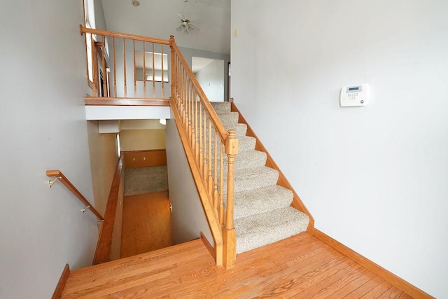 staircase featuring wood finished floors and baseboards