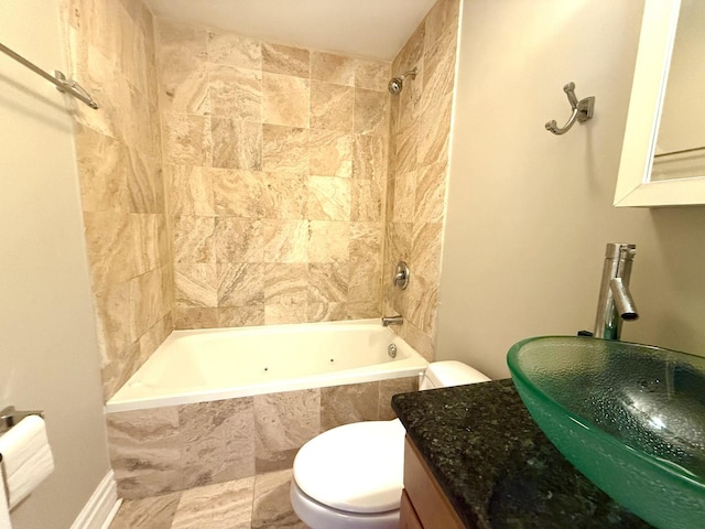 full bath featuring tiled shower / bath combo, a sink, and toilet